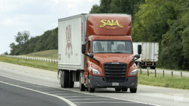 A red Saia tractor pulling a white Saia trailer on a highway