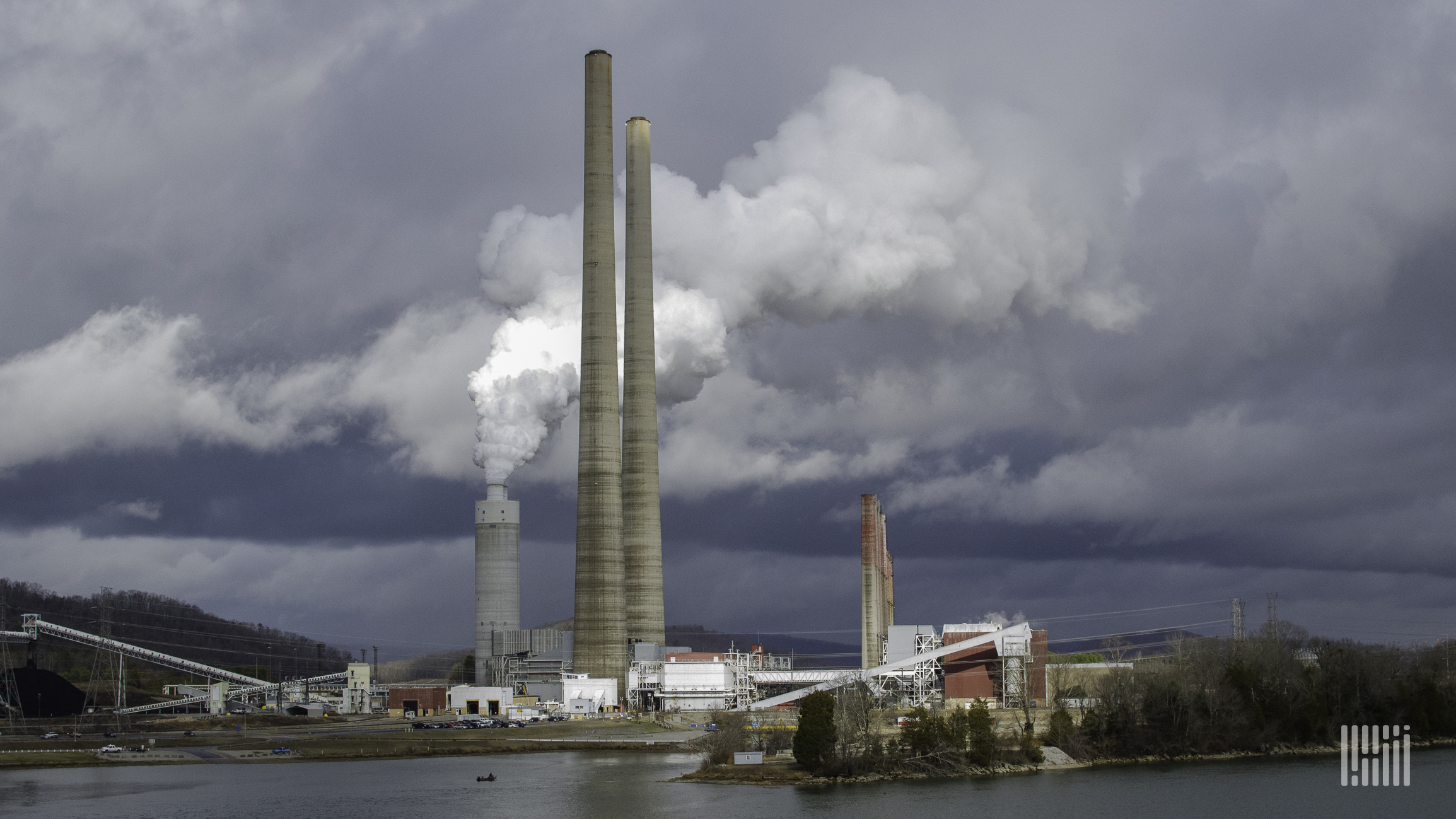 A supply chain factory has smoke emissions coming out of the factory.