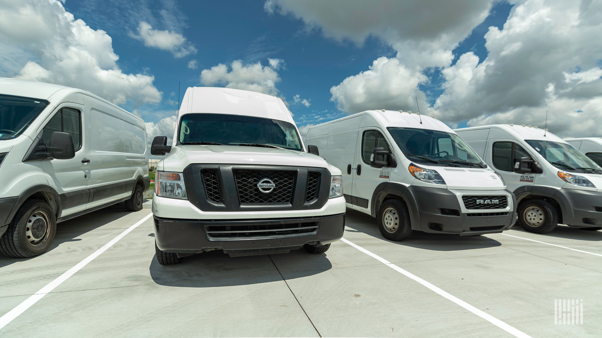 Row of vans sitting in a parking lot